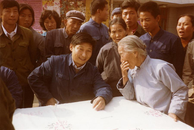 1983年，時(shí)任河北正定縣委書(shū)記的習近平（前排居中），臨時(shí)在大街上擺桌子聽(tīng)取老百姓意見(jiàn)。